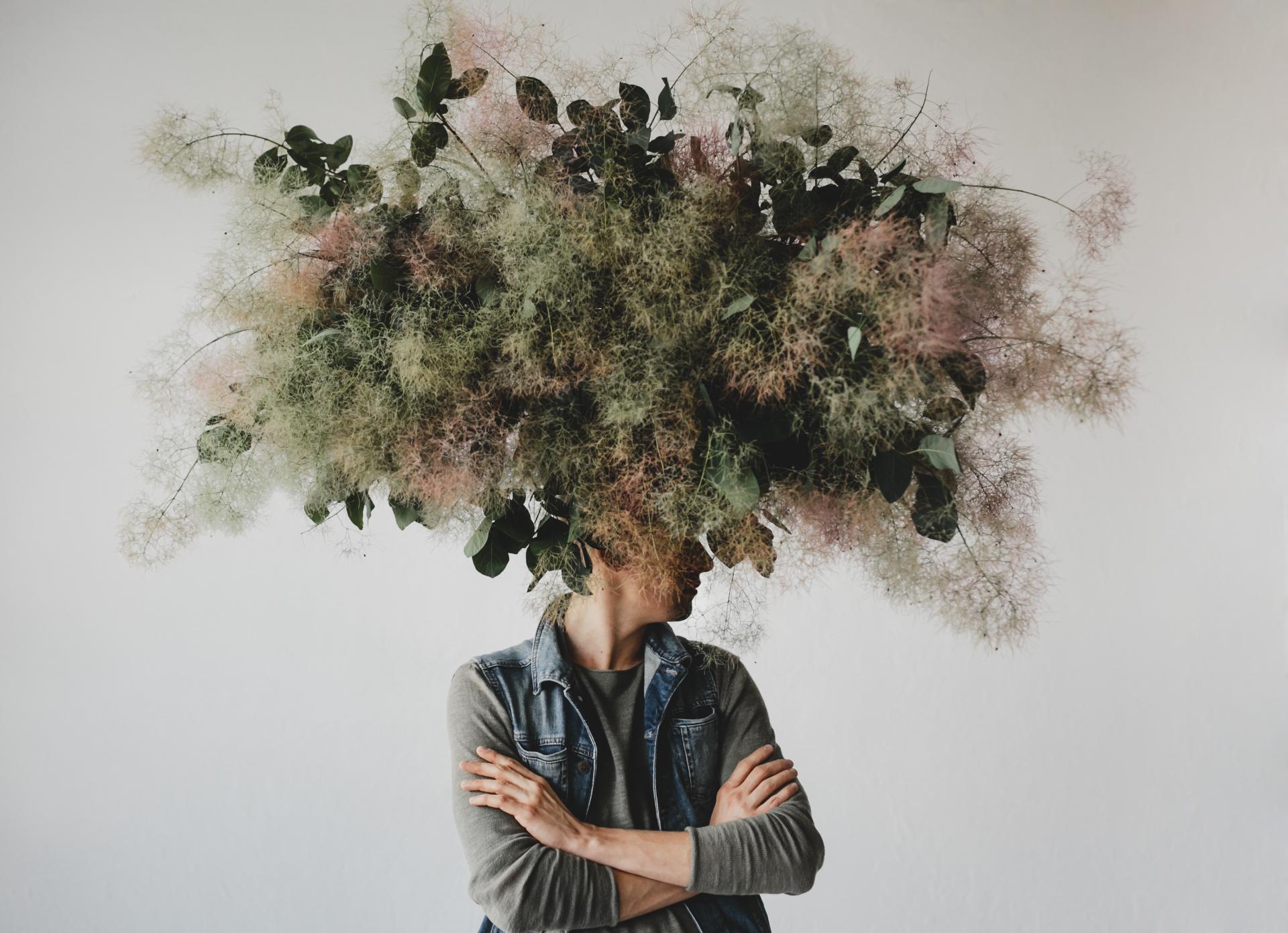 Large decorative bouquet made green leaves moss hangs man s head 1